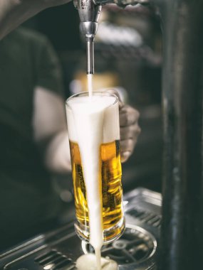 Garson köpük düşerken musluktan soğuk bira servisi yapıyor.