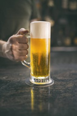 Barda bir barmen tarafından servis edilen bira bardağı.