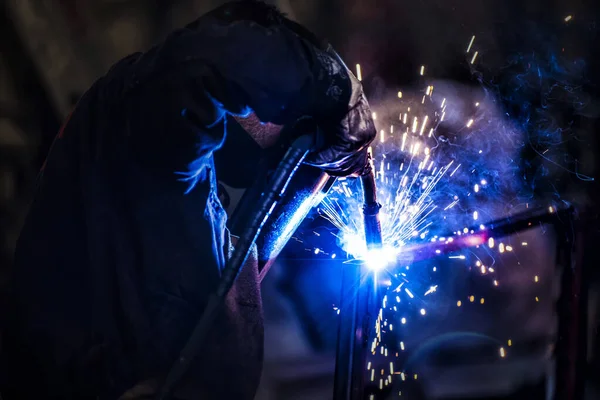 worker using a welding torch