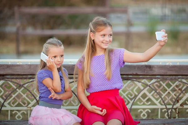 Dos chicas alegres tomando selfie en el parque . —  Fotos de Stock