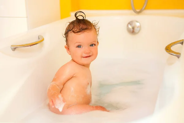 Smiling kid with foam and soap bubbles in bathroom. — Stockfoto