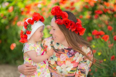 Mutlu kadın ve çocuk gelincik çayırında.