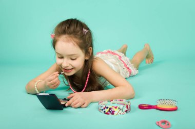 Küçük güzel kız makyaj yapıyor..