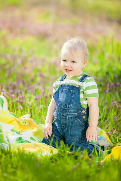 Küçük oğlan baharda yeşil bir alanda eğleniyor..