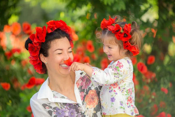 Mutlu kadın ve çocuk gelincik çayırında.