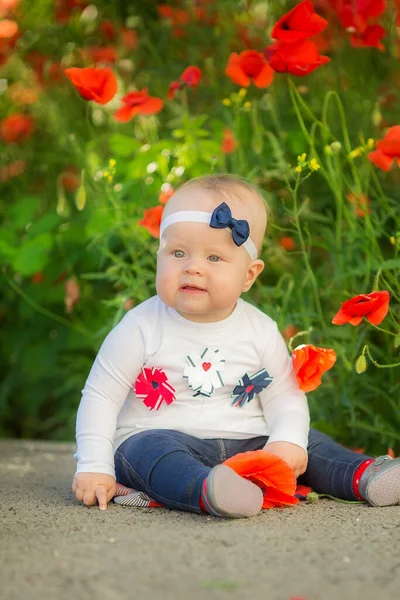 Retrato de uma linda menina se divertindo no campo de flores de papoula vermelha na primavera. — Fotografia de Stock