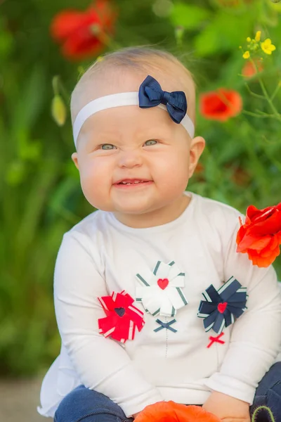 Retrato de uma linda menina se divertindo no campo de flores de papoula vermelha na primavera. — Fotografia de Stock
