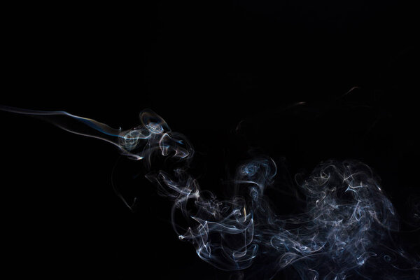 Freeze motion of smoke on black background. Abstract vape clouds.