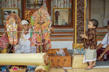 Gianyar / Bali-AĞUSTOS 14 2019: Gölge oyunu izleyen genç bir Balili çocuk. Wayang Kulit ya da Gölge kuklaları sürekli korunan bir Bali sanatıdır.