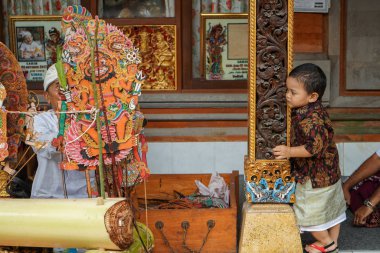 Gianyar / Bali-AĞUSTOS 14 2019: Gölge oyunu izleyen genç bir Balili çocuk. Wayang Kulit ya da Gölge kuklaları sürekli korunan bir Bali sanatıdır.