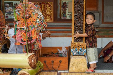 Gianyar / Bali-AĞUSTOS 14 2019: Gölge oyunu izleyen genç bir Balili çocuk. Wayang Kulit ya da Gölge kuklaları sürekli korunan bir Bali sanatıdır.