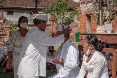 DENPASAR / BALI-MAY 7 2020: Salgın covid-19 patlak verdiğinde Bali 'de Hindu dini törenleri. Töreni yaparlar ve sağlık protokolüne uyarlar. Kendileri için hala maske kullandıklarını gördüm..