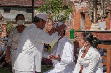 DENPASAR / BALI-MAY 7 2020: Salgın covid-19 patlak verdiğinde Bali 'de Hindu dini törenleri. Töreni yaparlar ve sağlık protokolüne uyarlar. Kendileri için hala maske kullandıklarını gördüm..
