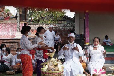 DENPASAR / BALI-MAY 7 2020: Salgın covid-19 patlak verdiğinde Bali 'de Hindu dini törenleri. Töreni yaparlar ve sağlık protokolüne uyarlar. Kendileri için hala maske kullandıklarını gördüm..