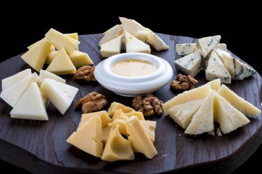 Tahta bir tahtanın üzerinde farklı peynirler. Peynir Kurulu.