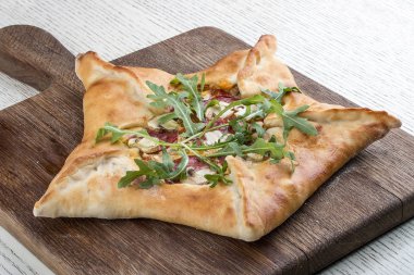 Tahtada jambon ve roka ile yıldız şeklinde pizza..