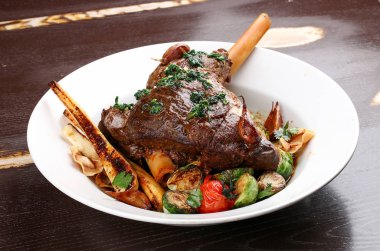 Kırmızı şarapta sebzeli kuzu budu.