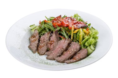 Biftekli salata ve beyaz arka planda kurutulmuş domates.