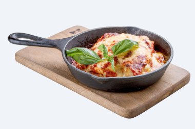 Tahtadaki dökme demir tavada lazanya. Geleneksel İtalyan yemeği