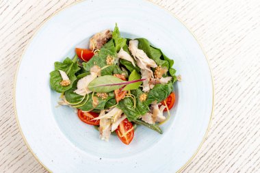 Tavuk ve domatesle salatayı karıştır. Hafif arkaplanda