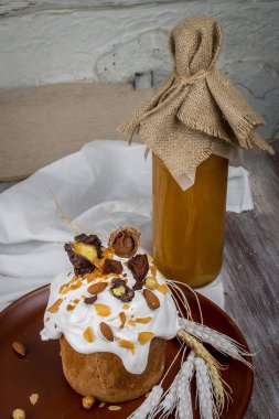 Süslü Paskalya sepeti, pasta, renkli yumurta ve likör. Tahta bir masada. 