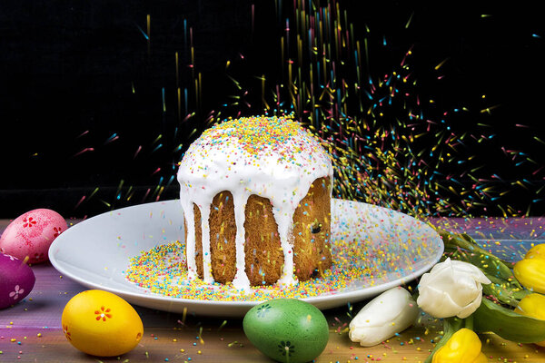 Easter eggs with cake on a white wooden table