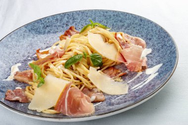 Pastırma ve jambonlu makarna. Geleneksel İtalyan yemeği. Beyaz bir arkaplanda