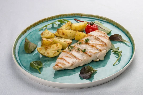 Grilled chicken fillet with fried potatoes. On light background