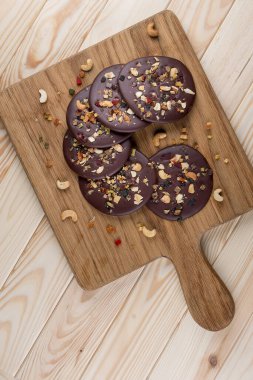 Tahta bir tahtanın üzerinde fındıklı çikolata parçalı kurabiyeler ve şekerli meyveler. Beslenme yemeği. Sağlıklı yemek..