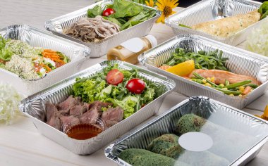 Hafif ahşap arka planda, konteynırlarda bulunan diyet yemekleri. Paket servis. Diyet ve sağlıklı yiyecekler.