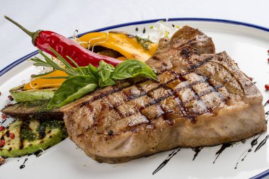 Izgara biftek ya da ızgara sebzeli biftek. Beyaz bir tabakta..