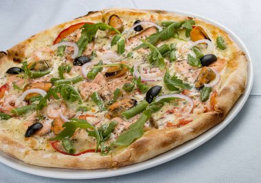 Somon, midye, zeytin, domates ve çeşitli baharatlı lezzetli sıcak pizza. Beyaz arkaplanda