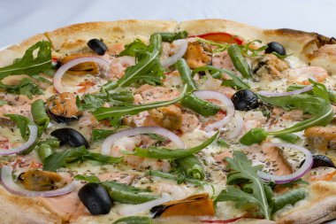 Somon, midye, zeytin, domates ve çeşitli baharatlı lezzetli sıcak pizza. Beyaz arkaplanda