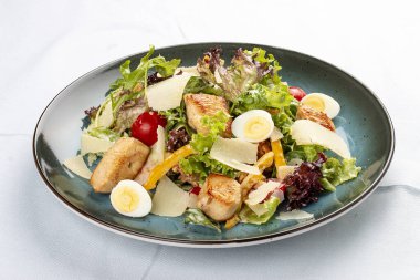 Sezar Salatası. Kızarmış tavuk göğsü, rendelenmiş parmesan peyniri ve salata soslu sos. Dekoratif bir tabakta