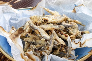 Ahşap arka planda parşömende kızartılmış sprat.