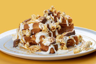 Karamel soslu Belçika waffleları, çikolata ve patlamış mısır..