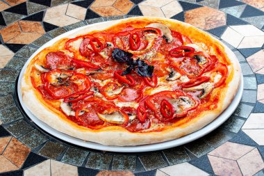 Chorizo ve biberli Diabola pizzası. Baharatlı yemek. Taş masada.