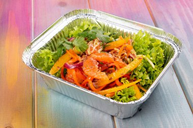 Renkli arka planda ızgara sebzeli ve greyfurtlu salata. Paket servis. Diyet ve sağlıklı yiyecekler.