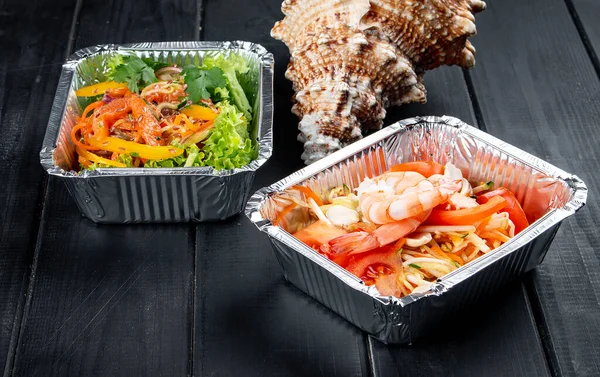 Koyu ahşap arka planda, kaplarda bir dizi diyet yemeği. Paket servis. Diyet ve sağlıklı yiyecekler.