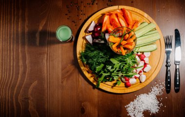 Tahtada taze kesilmiş sebzeler. Taze domates, salatalık, turp ve ottan oluşan aperatif. Sağlıklı beslenme, diyet, vejetaryenlik kavramı..