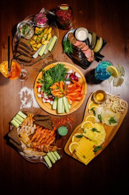 Masada bir sürü farklı lezzetli yemek var. Masada çeşitli abur cuburlar ve antipastalar var. Restoran menüleri. Restoran masası, bir sürü farklı yemek..