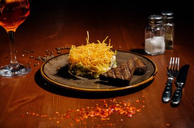 Tabakta peynir ve sebzeyle tabak ve ahşap bir masada tost..