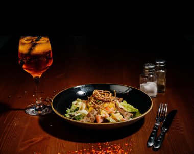 Tahta tabakta siyah tabakta Sezar salatası. Eski ahşap masada tavuklu taze sezar salatası..