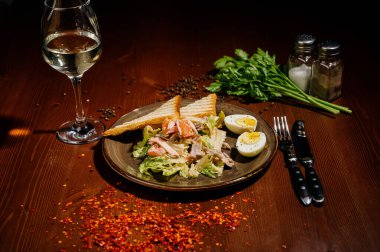 Tahta tabakta siyah tabakta Sezar salatası. Eski ahşap masada tavuklu taze sezar salatası..