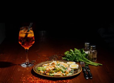 Tahta tabakta siyah tabakta Sezar salatası. Eski ahşap masada tavuklu taze sezar salatası..