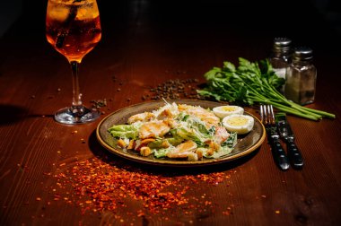 Tahta tabakta siyah tabakta Sezar salatası. Eski ahşap masada tavuklu taze sezar salatası..