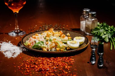 Tahta tabakta siyah tabakta Sezar salatası. Eski ahşap masada tavuklu taze sezar salatası..