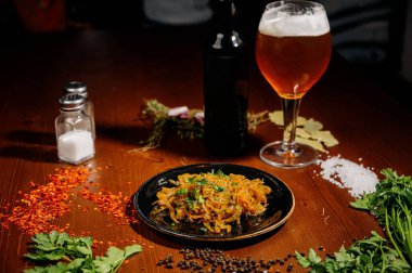 Bira ve abur cubur seçimi. Cips, balık, bira sosu. Masanın üzerinde soslu, koyu arkaplanda bir sürü farklı bira aperatifi.