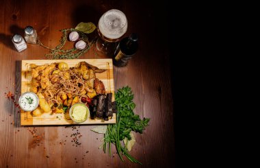 Bira ve abur cubur seçimi. Cips, balık, bira sosu. Masanın üzerinde soslu birçok farklı bira.