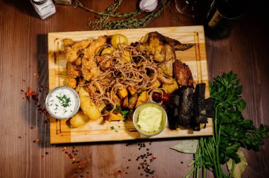 Bira ve abur cubur seçimi. Cips, balık, bira sosu. Masanın üzerinde soslu birçok farklı bira.